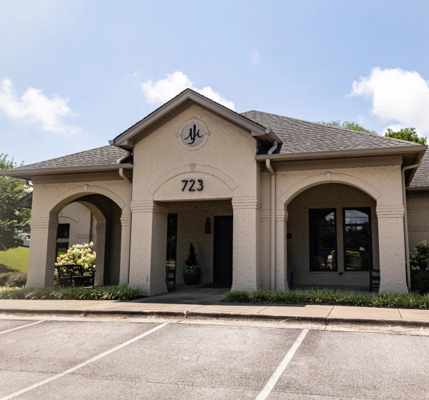 Modern dental office building with tan exterior, arched entryway, and professional landscaping at 723.