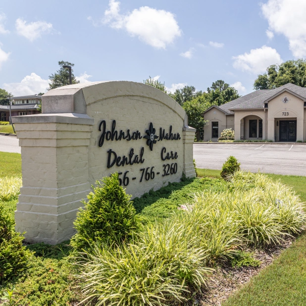 Johnson and Mahan Dental Care entrance sign with modern dental office building in background